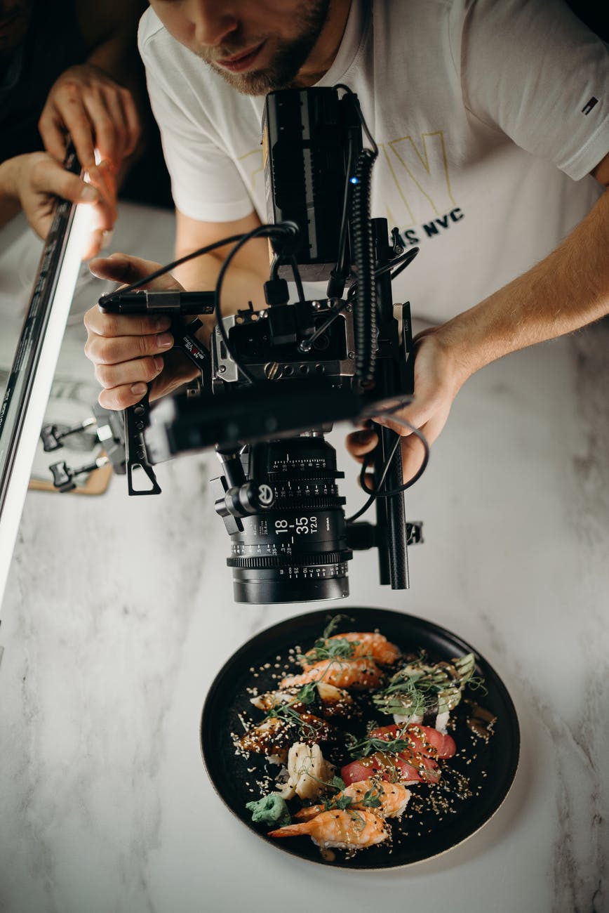 man using video camera pointing on food on plate